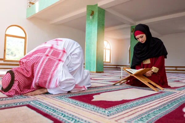 Мусульманский мужчина и женщина молятся в мечети — стоковое фото