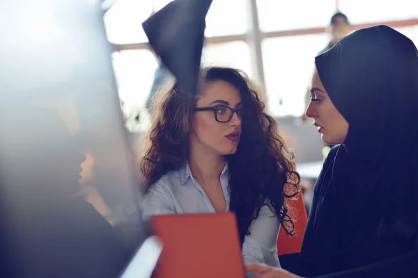 Duas mulheres de negócios muçulmanas trabalhando em seu laptop . — Fotografia de Stock