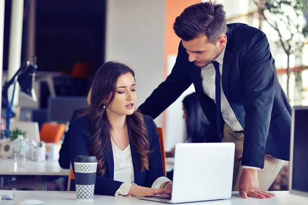 Concetto di startup business con giovane coppia multietnica in ufficio moderno che lavora su laptop — Foto Stock