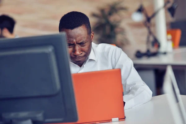 Enttäuschter afrikanischer Geschäftsmann ist benommen und verwirrt durch einen Fehler in offiziellen Dokumenten. — Stockfoto