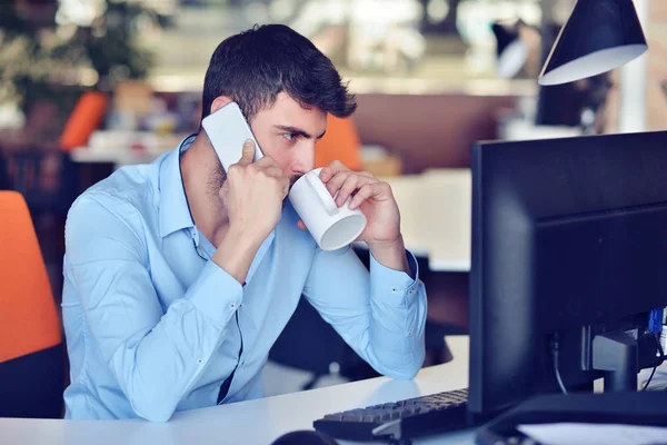 Empresário relaxante com as pernas na mesa, beber café enquanto sonha com o futuro no local de trabalho no escritório moderno . — Fotografia de Stock