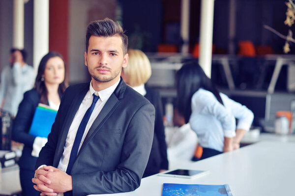 Портрет красивого бизнесмена перед его командой
