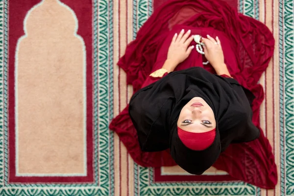 Вид сверху с воздуха Молодая красивая мусульманка, молящаяся в мечети — стоковое фото