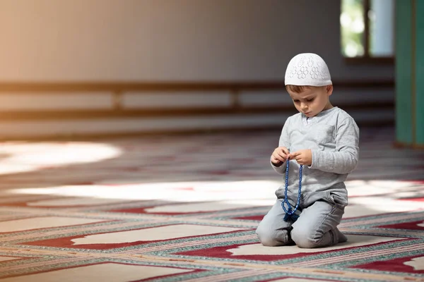 The Muslim child prays in the mosque, the little boy prays to God, Peace  and love in the holy month of Ramadan. Stock Photo by ©FS-Stock 168387888