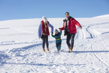 Çekici aile eğleniyor bir kış parkta dağda