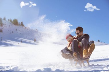 Kızak ve güneşli kış gününde zevk genç Çift