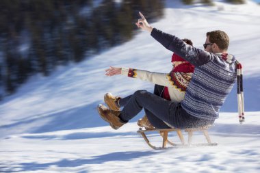 Kızak ve güneşli kış gününde zevk genç Çift
