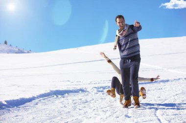 Genç oyuncu çift eğleniyor kar sledging kaplı tepe