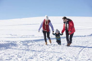 Çekici aile eğleniyor bir kış parkta dağda