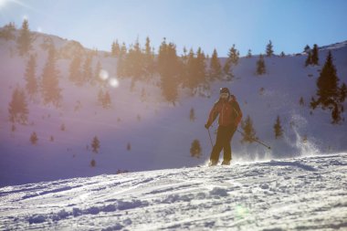 Yokuş aşağı günbatımı karşı yüksek dağlarda kayak kayakçı