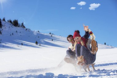 Kızak ve güneşli kış gününde zevk genç Çift