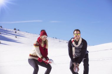 Kaygısız mutlu genç çift karda birlikte eğleniyor.
