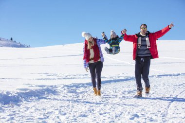 Çekici aile eğleniyor bir kış parkta dağda