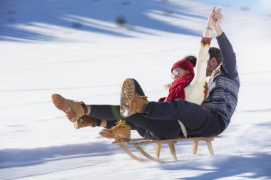 Kızak ve güneşli kış gününde zevk genç Çift