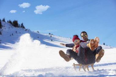 Kızak ve güneşli kış gününde zevk genç Çift