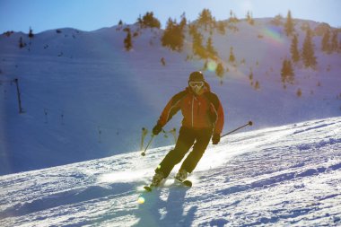 Yokuş aşağı günbatımı karşı yüksek dağlarda kayak kayakçı