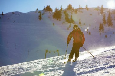 Yokuş aşağı günbatımı karşı yüksek dağlarda kayak kayakçı