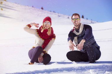 Kaygısız mutlu genç çift karda birlikte eğleniyor.