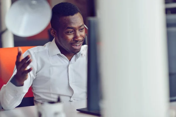 Afrikanischer amerikanischer Geschäftsmann sitzt im Startup-Büro am Computer — Stockfoto