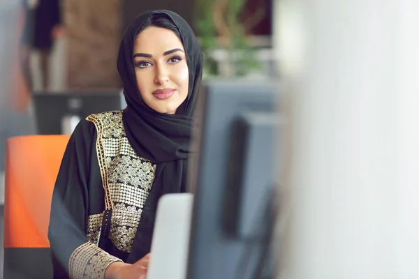 Мусульманская азиатка работает в офисе с ноутбуком — стоковое фото