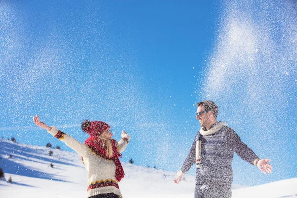 Despreocupado feliz joven pareja divirtiéndose juntos en la nieve . — Foto de Stock