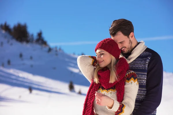 Happy couple playful together during winter holidays vacation outside in snow park