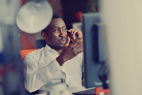 Afrikanischer amerikanischer Geschäftsmann sitzt im Startup-Büro am Computer — Stockfoto