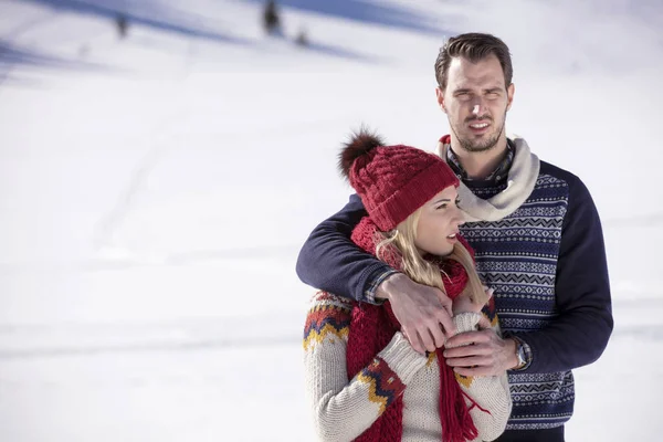 Happy couple playful together during winter holidays vacation outside in snow park