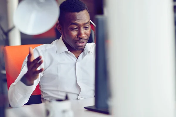 Afrikanischer amerikanischer Geschäftsmann sitzt im Startup-Büro am Computer — Stockfoto