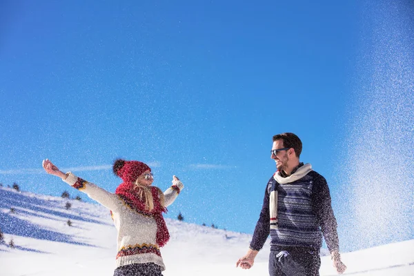Kaygısız mutlu genç çift karda birlikte eğleniyor.