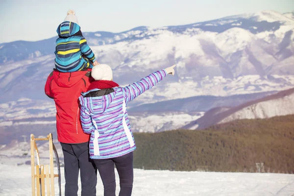 Padre, madre e hijos se están divirtiendo y jugando en invierno nevado caminar en la naturaleza . — Foto de Stock