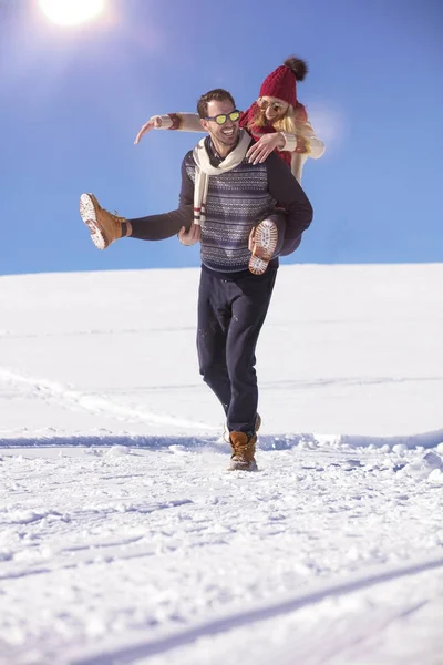 Pareja cariñosa jugando juntos en nieve al aire libre . — Foto de Stock