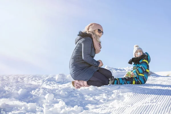 Счастливая семья мать и дочь веселятся, играя на зимней прогулке под открытым небом — стоковое фото