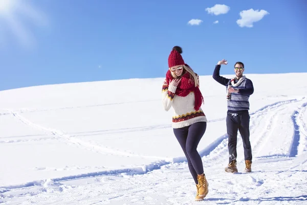 Carefree feliz jovem casal se divertindo juntos na neve . — Fotografia de Stock