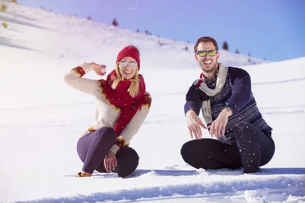 Беззаботная счастливая молодая пара веселится вместе на снегу . — стоковое фото