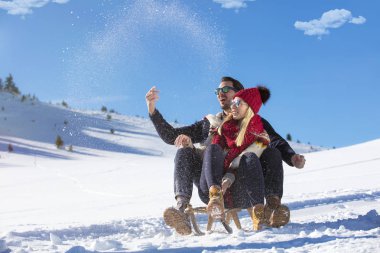 Kızak ve güneşli kış gününde zevk genç Çift