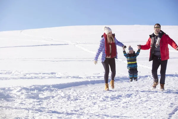 Família atraente se divertindo em um parque de inverno na montanha — Fotografia de Stock