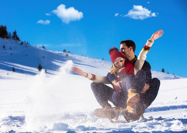 Pareja joven en trineo y disfrutando en el soleado día de invierno —  Fotos de Stock