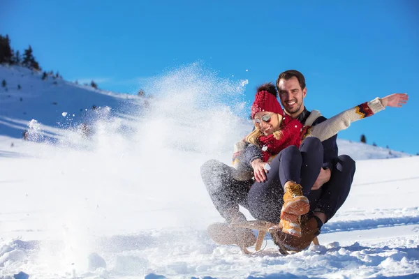 Casal jovem Sledding e desfrutar no dia ensolarado de inverno — Fotografia de Stock