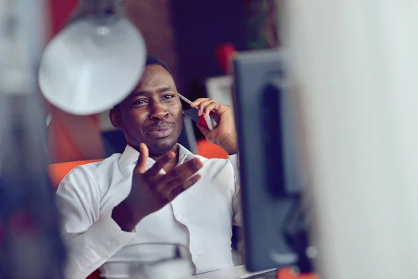 Afrikanischer amerikanischer Geschäftsmann sitzt im Startup-Büro am Computer — Stockfoto