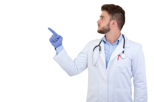 Retrato de un médico varón sonriente apuntando con el dedo aislado sobre un fondo blanco — Foto de Stock