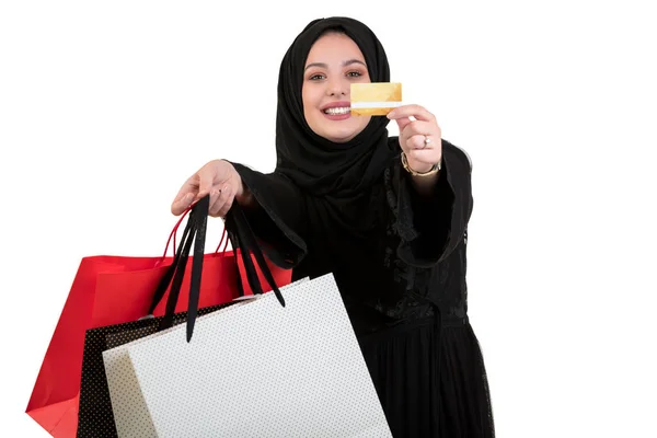 ショッピング バッグと白い背景上分離されたクレジット カードと立っているイスラム教徒の女性の幸せ — ストック写真