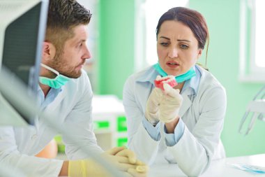 Diş protezleri, protezler, protezler. Takma diş üzerinde çalışırken protez eller.