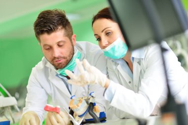 Diş protezleri, protezler, protezler. Takma diş üzerinde çalışırken protez eller.