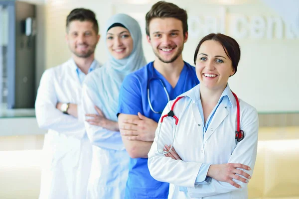 Retrato de un grupo feliz y confiado de doctores de pie en el consultorio médico —  Fotos de Stock