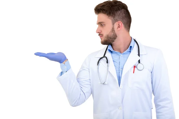 Retrato de um jovem sorridente médico masculino apontando dedo para longe isolado em um fundo branco — Fotografia de Stock