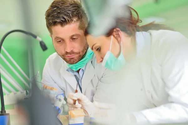 Próteses dentárias, dentaduras, próteses funcionam. Mãos protéticas enquanto trabalhava na prótese — Fotografia de Stock