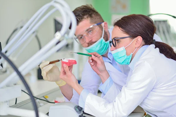 Las prótesis dentales, dentaduras postizas, prótesis funcionan. Manos de prótesis mientras se trabaja en la prótesis —  Fotos de Stock