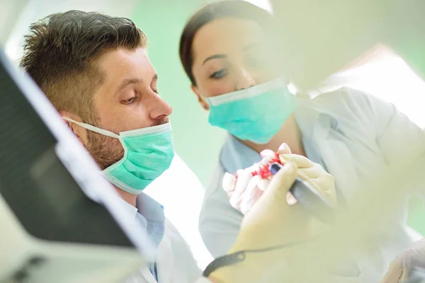 Las prótesis dentales, dentaduras postizas, prótesis funcionan. Manos de prótesis mientras se trabaja en la prótesis —  Fotos de Stock