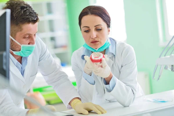 Las prótesis dentales, dentaduras postizas, prótesis funcionan. Manos de prótesis mientras se trabaja en la prótesis —  Fotos de Stock